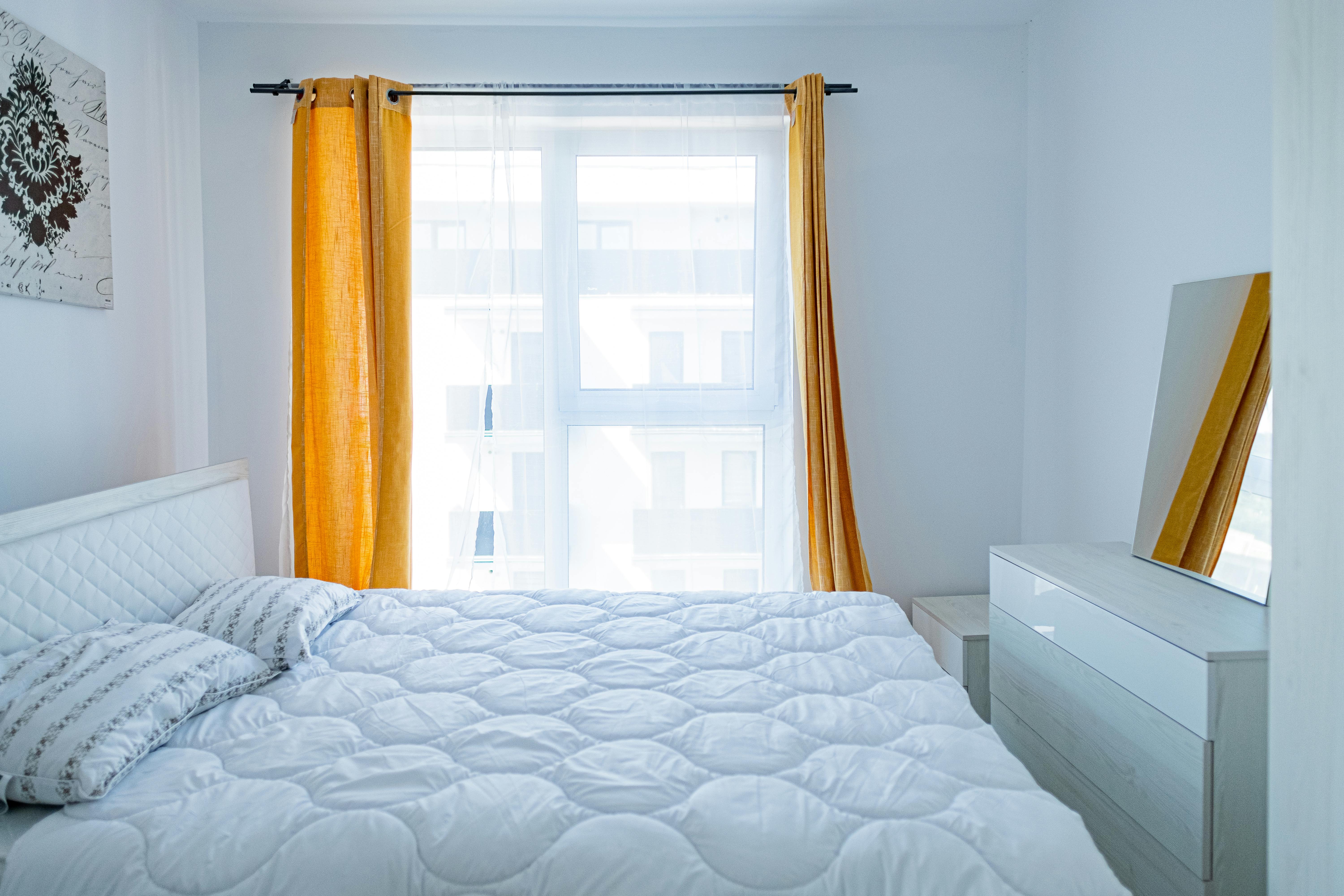 Dormitorio bien iluminado con colchón blanco en ambiente limpio y ordenado